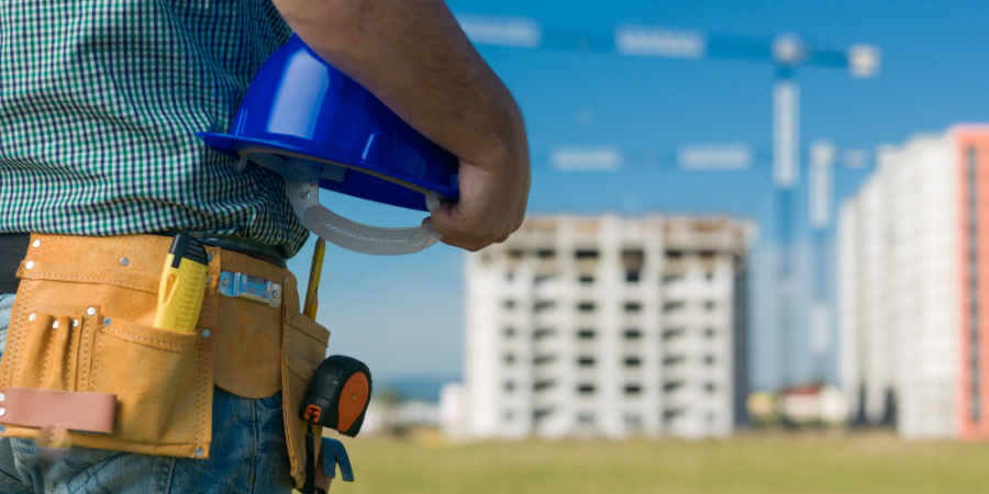 closeup of an engineer holding a hardhat with buildings in the background | closing the global skills gap