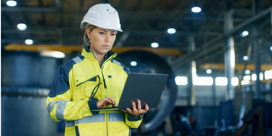woman in a hard hat using an LMS on her laptop | Ask These Critical Questions Before Buying an LMS