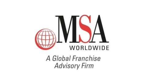 MSA Worldwide team reviewing brand standards documentation and structured franchise training materials during a strategic planning session.